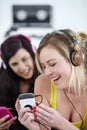 Enjoying the beat. Two young female friends listening to music on a mp3 player together. Royalty Free Stock Photo