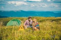 Enjoying the beautiful landscape of couples camping in the mountains. Happy couple tourists man and woman having a rest