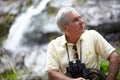 Enjoying the beautiful scenery. a senior man with binoculars looking at the scenery. Royalty Free Stock Photo