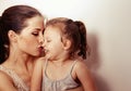 Enjoying beautiful young mother kissing and cuddling with love her cute baby girl. Closeup Royalty Free Stock Photo