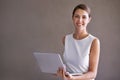 Enjoying the benefits of wireless technology. Portrait of a pretty young businesswoman holding a laptop on a white Royalty Free Stock Photo