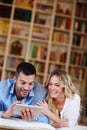 Enjoying a bit of light-hearted surfing. a young couple sitting at home using a digital tablet.