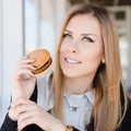 Enjoying burger: eating delicious hamburger beautiful young woman having fun in restaurant or coffee shop happy smile Royalty Free Stock Photo