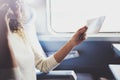 Enjoying business travel concept. Young beautiful brunette tourist girl travelling on the train sitting near the window