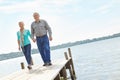 Enjoying a casual stroll. A loving elderly couple wallking along the pier.