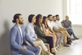 Concentrated happy business people listening intently sitting in a row in a classroom or office. Royalty Free Stock Photo