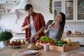 Enjoying cooking together. Young happy family couple, wife and husband having fun while preparing healthy food in the Royalty Free Stock Photo