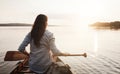 Enjoying the day in serenity. Rearview shot of a young woman enjoying a canoe ride at the lake. Royalty Free Stock Photo