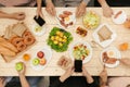 Enjoying dinner with friends. Top view of group of people having dinner together while sitting at wooden table Royalty Free Stock Photo