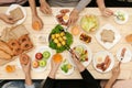 Enjoying dinner with friends. Top view of group of people having dinner together while sitting at wooden table Royalty Free Stock Photo