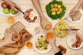 Enjoying dinner with friends. Top view of group of people having dinner together while sitting at wooden table