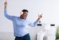 Black woman listening to music in headphones and dancing