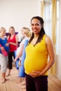 Enjoying a healthy pregnancy lifestyle. A happy young pregnant African-American woman holding her exercise mat while Royalty Free Stock Photo