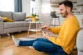 Enjoying his leisure time at home. Handsome young man using computer, relaxed at home Royalty Free Stock Photo