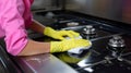 Enjoying household duties Gloved female hand cleans stove, housewifes satisfaction palpable