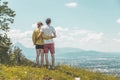 Enjoying the idyllic mountain landscape: Couple is standing on idyllic meadow and enjoying the view over the far away city of Royalty Free Stock Photo