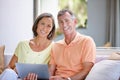 Enjoying a leisurely day at home together. Portrait of a loving mature couple relaxing with a digital tablet at home. Royalty Free Stock Photo