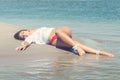 Enjoying life beautiful woman lying in wet sand on the beach Sum Royalty Free Stock Photo