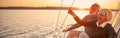 Enjoying luxury life. Beautiful happy senior couple in love relaxing on the side of sailboat or yacht deck floating in Royalty Free Stock Photo