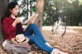 Enjoying moment hipster woman reading a book and sitting under the big tree on park Royalty Free Stock Photo