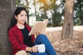 Enjoying moment hipster woman reading a book and sitting under the big tree on park Royalty Free Stock Photo