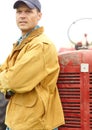 Enjoying a moment of solitude. a farmer standing next to his tractor with his arms crossed. Royalty Free Stock Photo