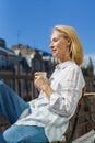 Happy elderly woman sitting on terrace with cup of coffee and enjoying beautiful sunny morning Royalty Free Stock Photo