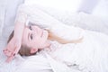 Attractive female in white lingerie relaxing at home on her windowsill