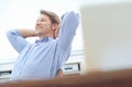 Enjoying my business. Relaxed, attractive businessman sitting back in an office chair with his hands behind his head. Royalty Free Stock Photo