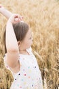 Enjoying the nature. Little girl stay in the golden wheat field Royalty Free Stock Photo