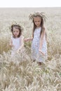 Enjoying the nature. Two little girls stay in the golden wheat field Royalty Free Stock Photo