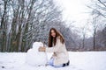 Enjoying nature wintertime. Winter woman happy. Beautiful girl in the winter forest in white down jacket. Royalty Free Stock Photo
