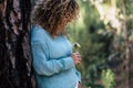 Enjoying the nature - Young woman care a little coloured fresh flower in the wood - concept of save the planet and care the earth