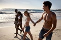 Enjoying a perfect day on the beach. Two young couples taking a walk on the beach together. Royalty Free Stock Photo