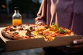 Enjoying pizza with friends outdoors, captured from a side angle