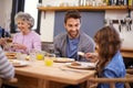 Enjoying a scrumptious breakfast together. a family eating breakfast around the kitchen table.