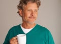 Enjoying something warm on a cold afternoon. Cropped studio shot of a handsome mature man holding a mug. Royalty Free Stock Photo