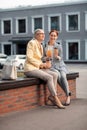 Two modern women sitting on the bench outdoors