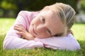 Enjoying the summer sun. Portrait of a young girl lying on the grass outside. Royalty Free Stock Photo