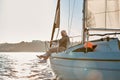 Enjoying sunset. Side view of a senior couple sitting on the side of a sailboat or yacht deck floating in a calm blue Royalty Free Stock Photo