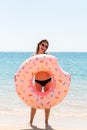 Enjoying suntan. Beautiful crazy woman relaxing and playing with inflatable ring in sea beach. Summer holidays and vacation Royalty Free Stock Photo