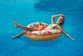 Enjoying suntan Woman in bikini on the inflatable mattress in the swimming pool. Royalty Free Stock Photo