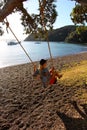 Enjoying a swing down by the beach at sunset Royalty Free Stock Photo