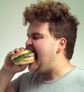 Enjoying a tasty burger. Closeup shot of a man biting into a burger.