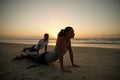 Enjoying their yoga session by the sea. a couple doing yoga on the beach at sunset. Royalty Free Stock Photo