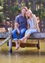 Enjoying a weekend getaway at the lake. A loving married couple enjoying a moment on the jetty at the lake. Royalty Free Stock Photo