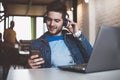 Enjoying work and good music. Cheerful young man in headphones listening to the music Royalty Free Stock Photo