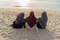 Enjoyinng sunset at the beach. Asian hijab women sitting on seashore at sunset. rest and relaxation concept Royalty Free Stock Photo