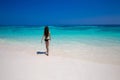 Enjoyment. Beautiful bikini woman walking on tropical beach, slim girl with long hair entering the sea water with white sand on Royalty Free Stock Photo