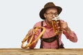 Enjoyment. Portrait of delightful bearded man in hat and traditional Bavarian costume with glass of frothy beer isolated Royalty Free Stock Photo